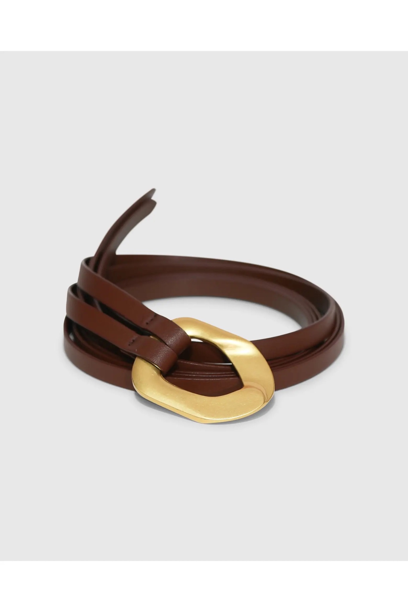 Brown Belle & Bloom Dream On Belt with a sculptural gold-tone buckle on a soft gray background