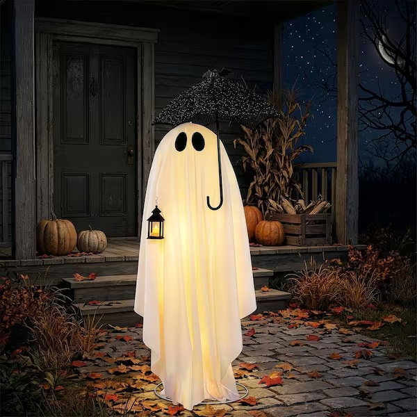 Illuminated white ghost with bat-covered umbrella and lantern in an outdoor Halloween porch setting